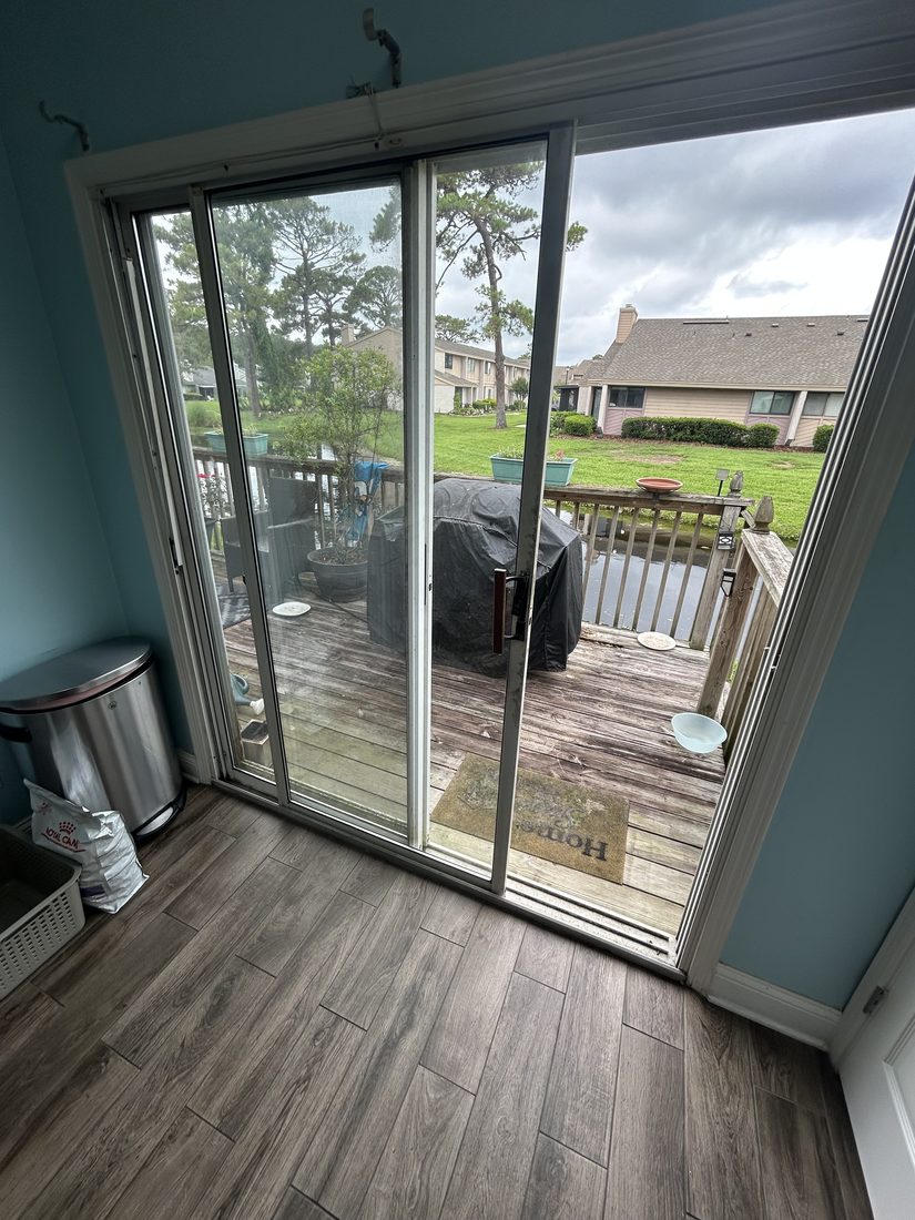 Repaired sliding door rolling smoothly open onto a deck