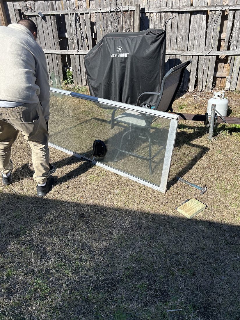 Technician carrying a glass door panel during installation