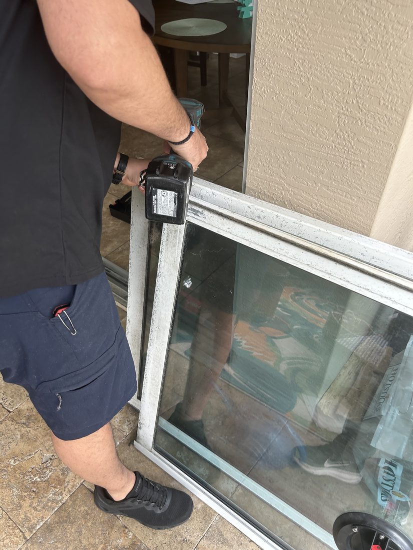 Technician working on a sliding glass door frame on site