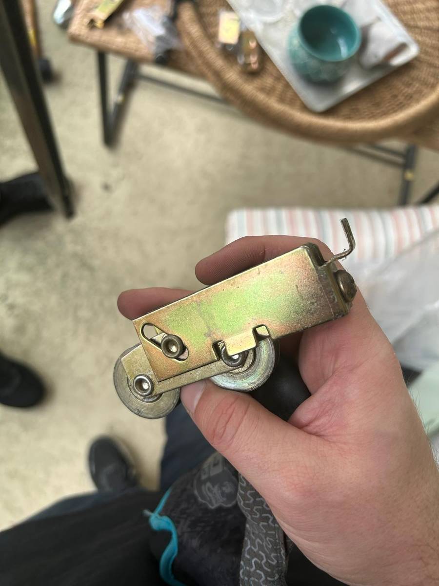New dual-wheel roller assembly ready to replace the worn hardware causing a hard-to-open door