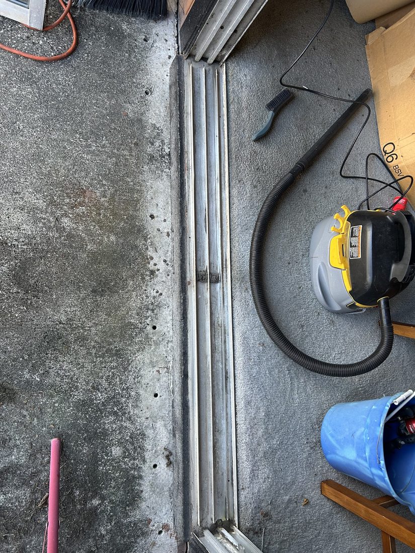 Sliding door track being cleaned and serviced